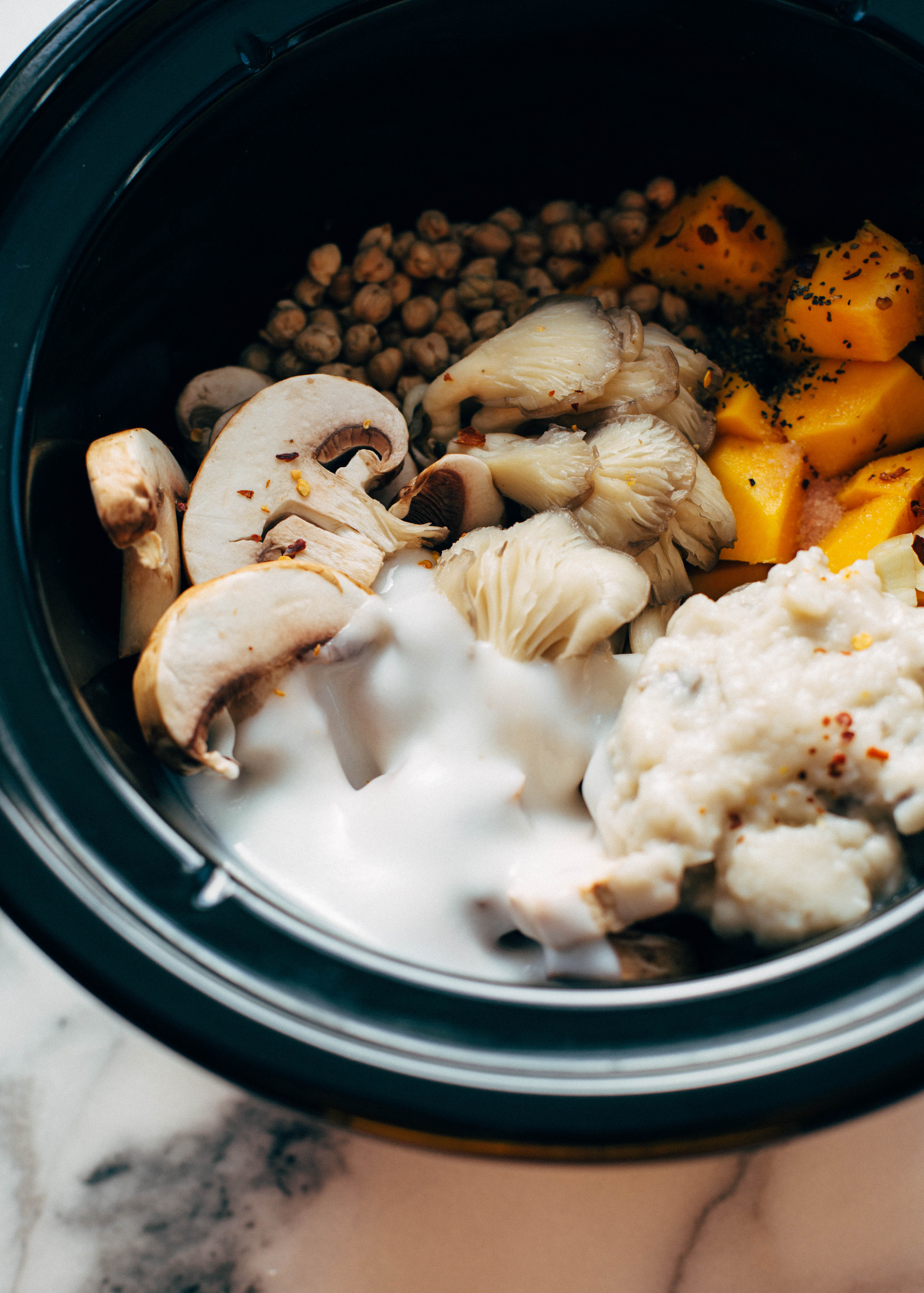 pumpkin stew in crock pot with uncooked ingredients